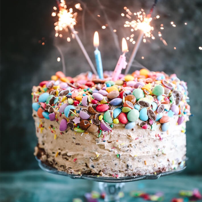 Sjokoladekake med fargerike sjokoladeknapper, stjerneskudd og lys
