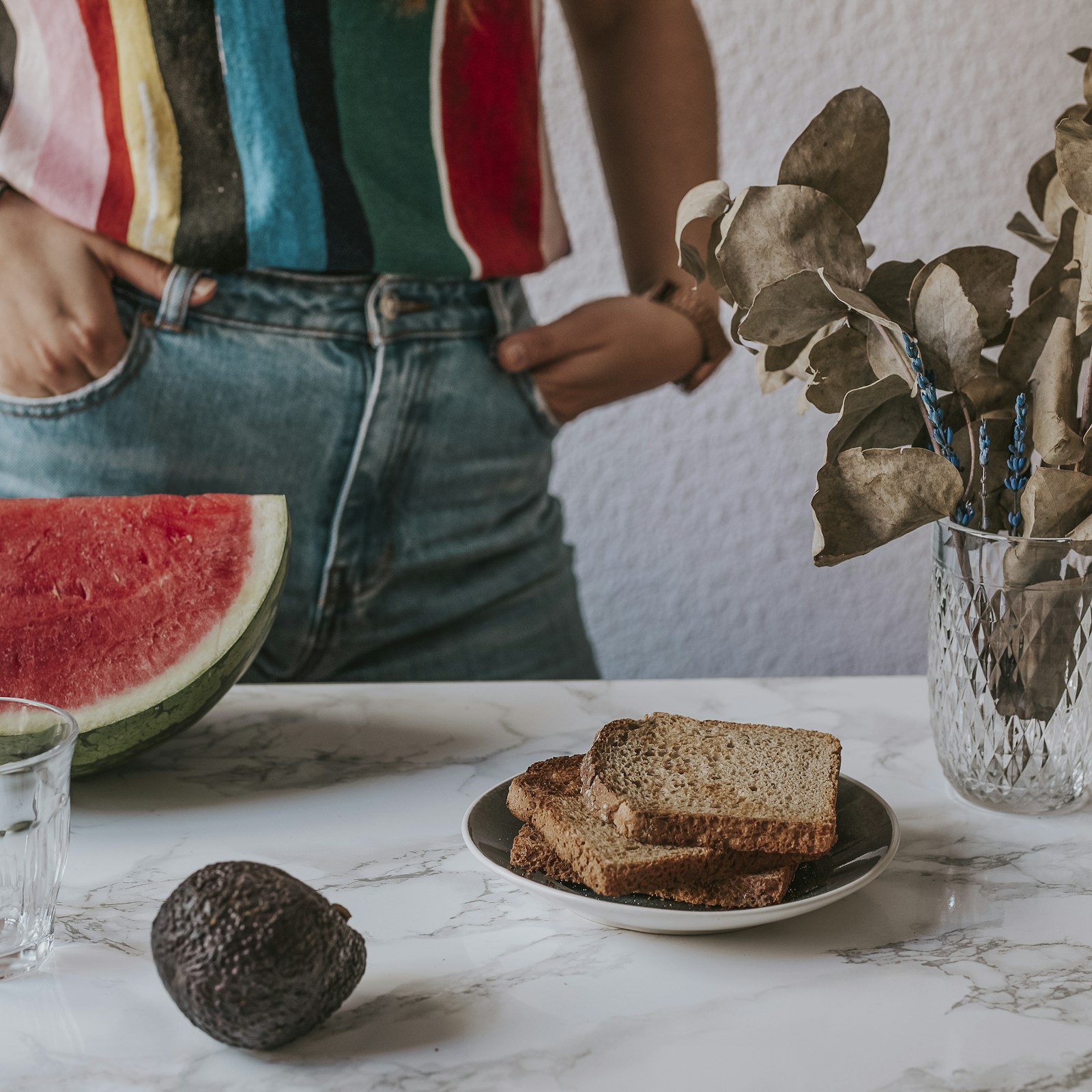 Grovbrød, vannmelon og avokado på et bord