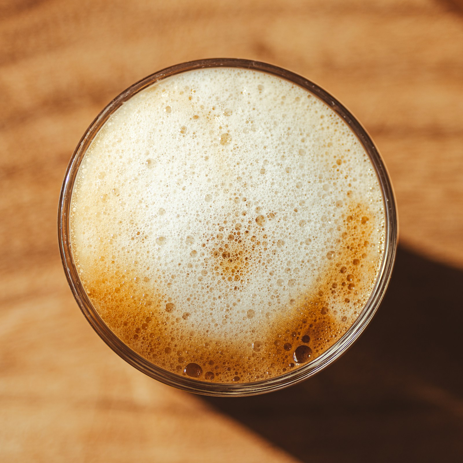 Glass med kaffe og tykt skum sett ovenfra