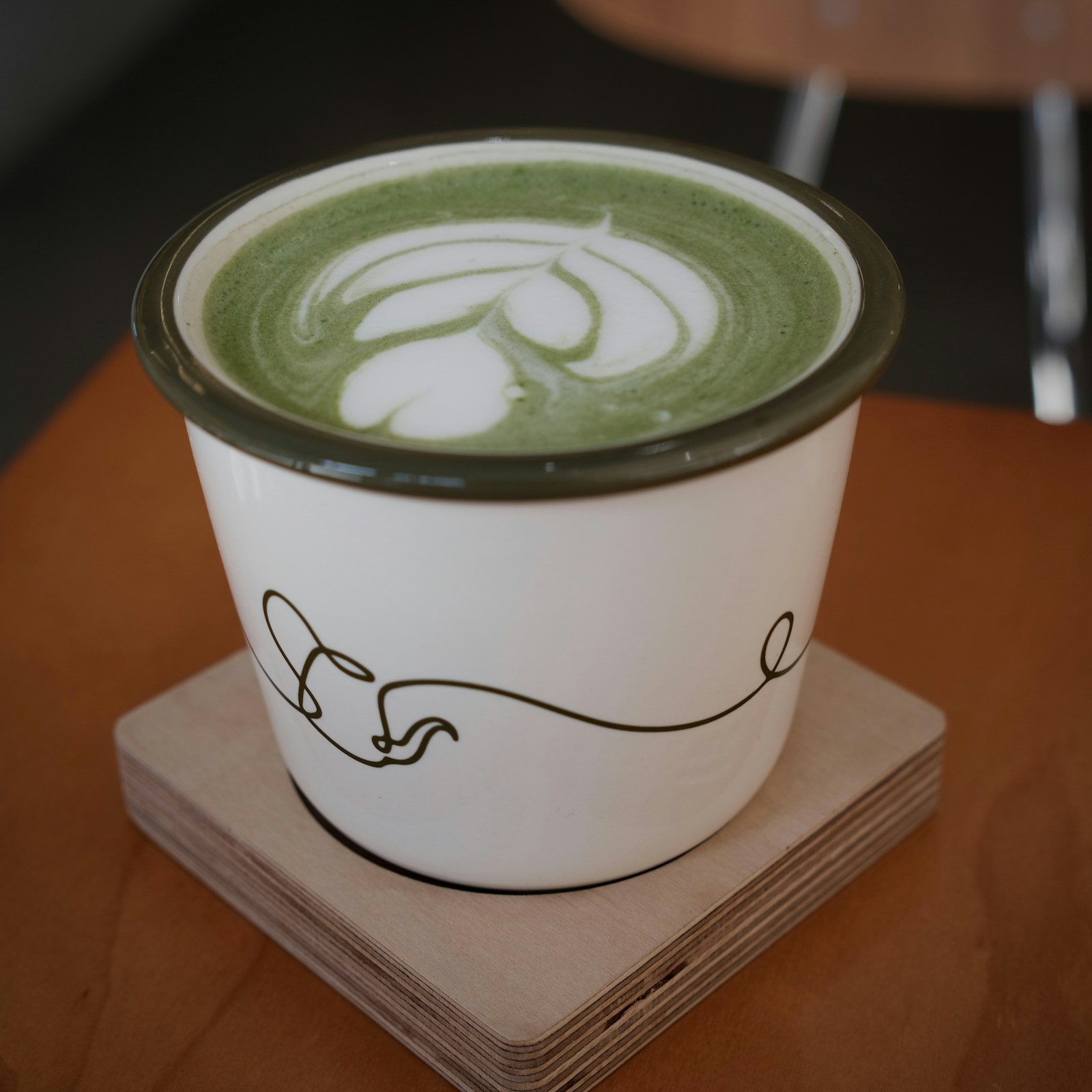 Matcha latte med skumkunst i hvit kopp