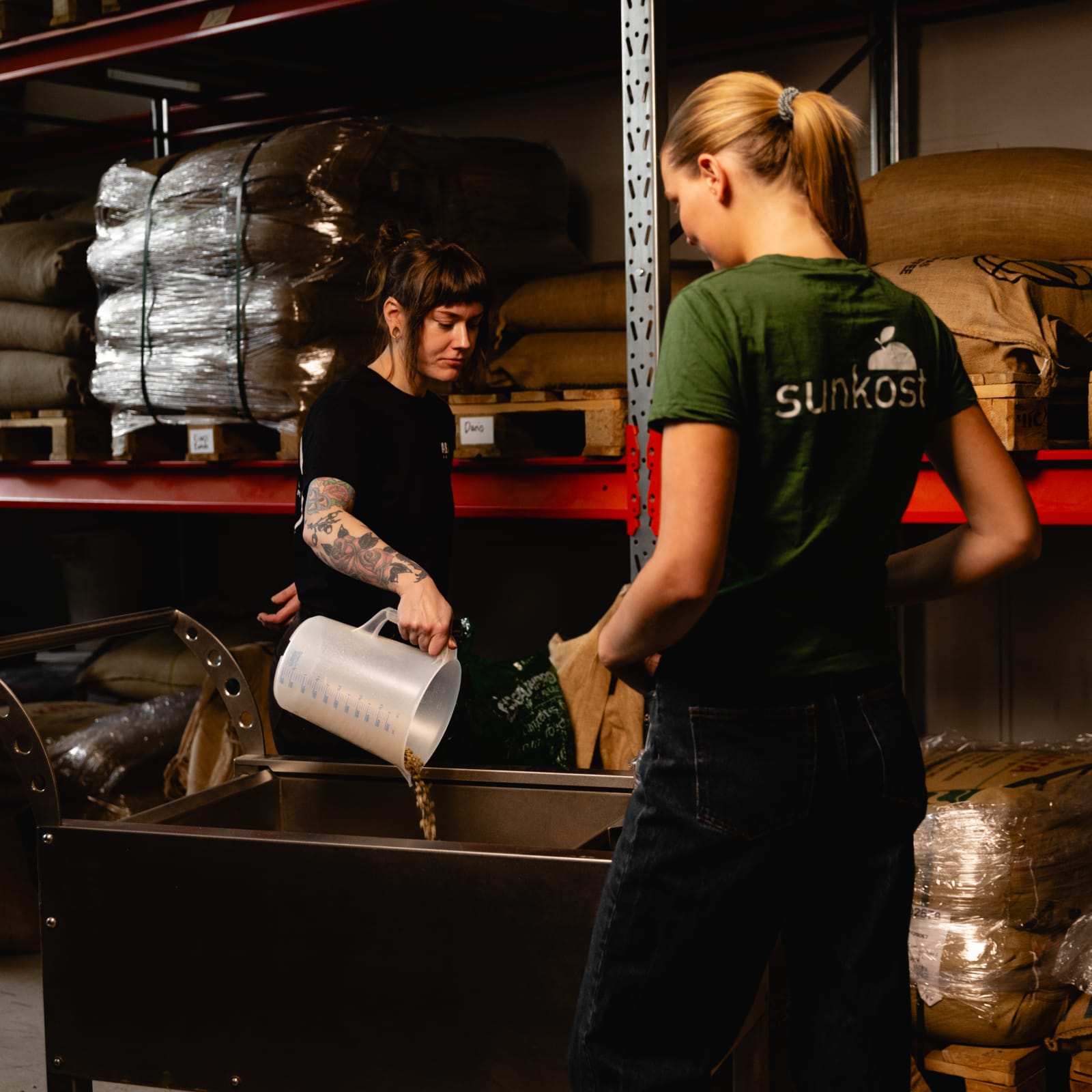 To Sunkost-ansatte heller kaffebønner i en rister